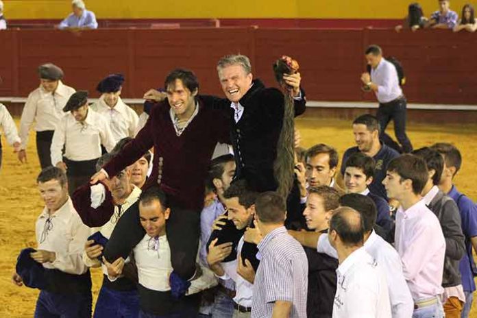 Novilleros y aficionados izan a hombros a Espartaco junto a Andrés Romero esta tarde en Palos al finalizar el triunfal festejo. (FOTO: Laura Barba)