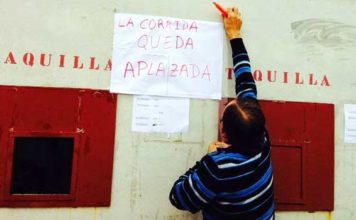 Un operario de la plaza coloca el cartel del 'aplazamiento' de la corrida 'pinzoniana'. (FOTO: Arizmendi)