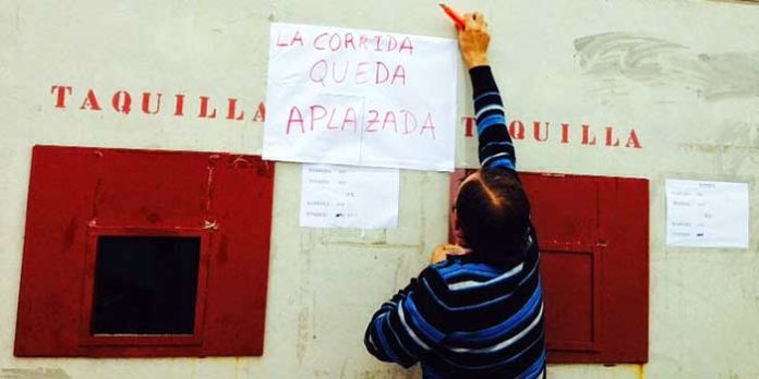 Un operario de la plaza coloca el cartel del 'aplazamiento' de la corrida 'pinzoniana'. (FOTO: Arizmendi)